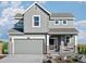 Charming two-story home featuring a gray exterior, a two-car garage and a welcoming front porch at 907 W Beverly St, Elizabeth, CO 80107