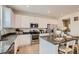 Bright kitchen featuring white cabinets, stainless steel appliances, an island and dark counter tops at 907 W Beverly St, Elizabeth, CO 80107