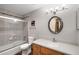 Bathroom with tiled shower and tub, wood vanity, and a large oval mirror above the sink at 107 N Harris St # 102, Breckenridge, CO 80424