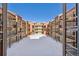 An outdoor condo courtyard filled with snow, framed by balconies and light colored siding at 107 N Harris St # 102, Breckenridge, CO 80424