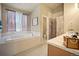 Bright bathroom featuring a soaking tub, walk-in shower, double vanity, and lots of natural light at 925 Antelope W Dr, Bennett, CO 80102