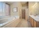 Bright bathroom featuring a soaking tub, walk-in shower, double vanity, and lots of natural light at 925 Antelope W Dr, Bennett, CO 80102
