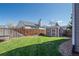 Spacious backyard featuring a shed, green lawn, wooden fence, and landscaping, perfect for outdoor activities at 87 Macon Ct, Aurora, CO 80010