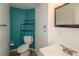 Cozy bathroom featuring teal accent wall, vanity with mirror, and toilet with storage at 87 Macon Ct, Aurora, CO 80010
