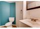 Traditional bathroom with toilet, vanity, sink, mirror, and towel ring at 87 Macon Ct, Aurora, CO 80010