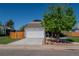 Home exterior showcasing a two-car garage, landscaped front yard, mature tree, and well-maintained lawn at 87 Macon Ct, Aurora, CO 80010