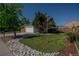 Beautiful home with a well-manicured front yard, rock landscaping, mature trees, and a two-car garage at 87 Macon Ct, Aurora, CO 80010