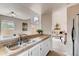 Kitchen with stone countertop and stainless steel sink overlooking the living room and backyard at 87 Macon Ct, Aurora, CO 80010