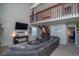 Spacious living room featuring a large sectional, TV, and staircase to the second floor at 87 Macon Ct, Aurora, CO 80010