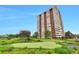 Stunning high-rise building featuring a well-manicured lawn, putting green, and lovely landscaping at 3131 E Alameda Ave # 704, Denver, CO 80209