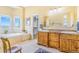 Bathroom with dual vanities, a soaking tub, and access to a walk-in closet at 3221 Autumn Sun Cir, Castle Rock, CO 80104