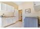 Laundry room with white cabinets, countertop, modern washer, and easy access to the house at 3221 Autumn Sun Cir, Castle Rock, CO 80104