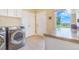 Bright laundry area with modern washer and dryer, storage cabinets, and a window view at 3221 Autumn Sun Cir, Castle Rock, CO 80104