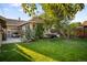 Large backyard with a patio, an outdoor dining area, hammock, a manicured lawn, and privacy fence at 2026 S Lincoln St, Denver, CO 80210