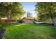 A backyard with a lush lawn, mature trees, wooden fence, and a cozy hammock at 2026 S Lincoln St, Denver, CO 80210