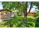 Backyard with a well-kept lawn, established trees, a brick garage, and a comfortable hammock at 2026 S Lincoln St, Denver, CO 80210