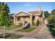 Charming brick home with a cozy front porch, a well-manicured lawn, and private driveway at 2026 S Lincoln St, Denver, CO 80210