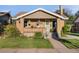 Charming brick home with a cozy front porch, a well-manicured lawn, and tasteful landscaping at 2026 S Lincoln St, Denver, CO 80210