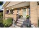 Inviting front porch with brick accents, decorative plants and room for seating at 2026 S Lincoln St, Denver, CO 80210