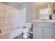 Well-lit full bathroom featuring tub with shower, toilet and vanity with storage, with vinyl floors at 9605 Elk Mountain Cir, Littleton, CO 80125