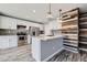 Modern kitchen with stainless steel appliances, gray countertops, a decorative accent wall and light hardwood flooring at 9605 Elk Mountain Cir, Littleton, CO 80125