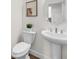 Clean half bath featuring a pedestal sink, toilet, and contemporary decor at 1665 Diamond Head Dr, Castle Rock, CO 80104