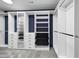 Custom walk-in closet with ample shelving, drawers, and rods for organization against a navy blue accent wall at 1665 Diamond Head Dr, Castle Rock, CO 80104