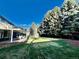 A well-manicured backyard features a covered patio with chairs and a playhouse at 4640 W Princeton Ave, Denver, CO 80236