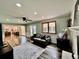 Sunlit living room with hardwood floors, a ceiling fan, and a view into the kitchen at 4640 W Princeton Ave, Denver, CO 80236