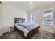 Inviting bedroom with a dark wooden bed frame, neutral decor, and ample natural light from two windows at 10991 Xanadu St, Commerce City, CO 80022