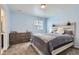 Sunny bedroom with a rustic wood headboard, warm carpeting, and a wooden dresser for storage at 10991 Xanadu St, Commerce City, CO 80022