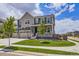Charming two-story home featuring a well-manicured lawn, mature trees, and a three-car garage at 10991 Xanadu St, Commerce City, CO 80022