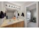 Bright bathroom featuring double sinks, a large mirror with modern lighting, and ample cabinet storage at 4357 W 118Th Pl, Westminster, CO 80031