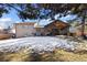 Exterior view of a backyard featuring a covered patio, an outdoor kitchen, mature trees, and a well-maintained lawn at 7233 S Harrison Way, Centennial, CO 80122