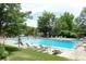 Community swimming pool featuring plenty of lounge chairs, umbrellas, and a lifeguard on duty at 7233 S Harrison Way, Centennial, CO 80122