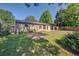 Spacious backyard featuring a brick patio, a well-maintained lawn, and mature trees, perfect for outdoor living at 6054 Iris Way, Arvada, CO 80004