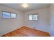 This bedroom has hardwood floors and two windows at 6054 Iris Way, Arvada, CO 80004