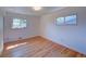 Empty bedroom with two windows, hardwood floors, and white walls at 6054 Iris Way, Arvada, CO 80004