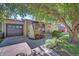 Charming brick home featuring an attached garage, mature tree, and a well-maintained front yard at 6054 Iris Way, Arvada, CO 80004