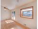 Living room with light hardwood floors, neutral paint, and a large window providing natural light at 6054 Iris Way, Arvada, CO 80004