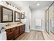 Bathroom featuring dual sinks, dark wood cabinets, granite countertop, and glass-enclosed shower at 10000 E Yale Ave # 41, Denver, CO 80231