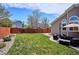 The backyard has a green lawn, mature trees, patio seating, and a privacy fence at 18477 E Amherst Dr, Aurora, CO 80013