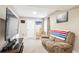 Spacious finished basement featuring carpet floors, a comfortable recliner, and a large-screen television at 18477 E Amherst Dr, Aurora, CO 80013