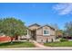 Charming single Gathering home showcasing a well-manicured lawn, mature tree, and inviting brick accents beneath neutral siding at 18477 E Amherst Dr, Aurora, CO 80013