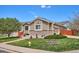 Well maintained home featuring neutral siding, manicured lawn, mature landscaping, and brick accents, creating a welcoming curb appeal at 18477 E Amherst Dr, Aurora, CO 80013