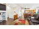 Open-concept living space with dark wood floors leading to kitchen with central island and stainless appliances at 18477 E Amherst Dr, Aurora, CO 80013