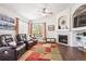Inviting living room features a cozy fireplace, ceiling fan, and large windows for ample natural light at 18477 E Amherst Dr, Aurora, CO 80013