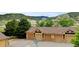 Row of garages with brown doors and stone accents, with lush greenery and mountains in the background, indicating a well-maintained community at 8726 S Kline St # A204, Littleton, CO 80127