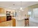Open kitchen with a breakfast bar, wooden cabinets, stainless steel appliances, and modern lighting at 8726 S Kline St # A204, Littleton, CO 80127