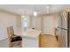 Kitchen island with barstool seating, stainless steel refrigerator, and views of the hallway at 8726 S Kline St # A204, Littleton, CO 80127